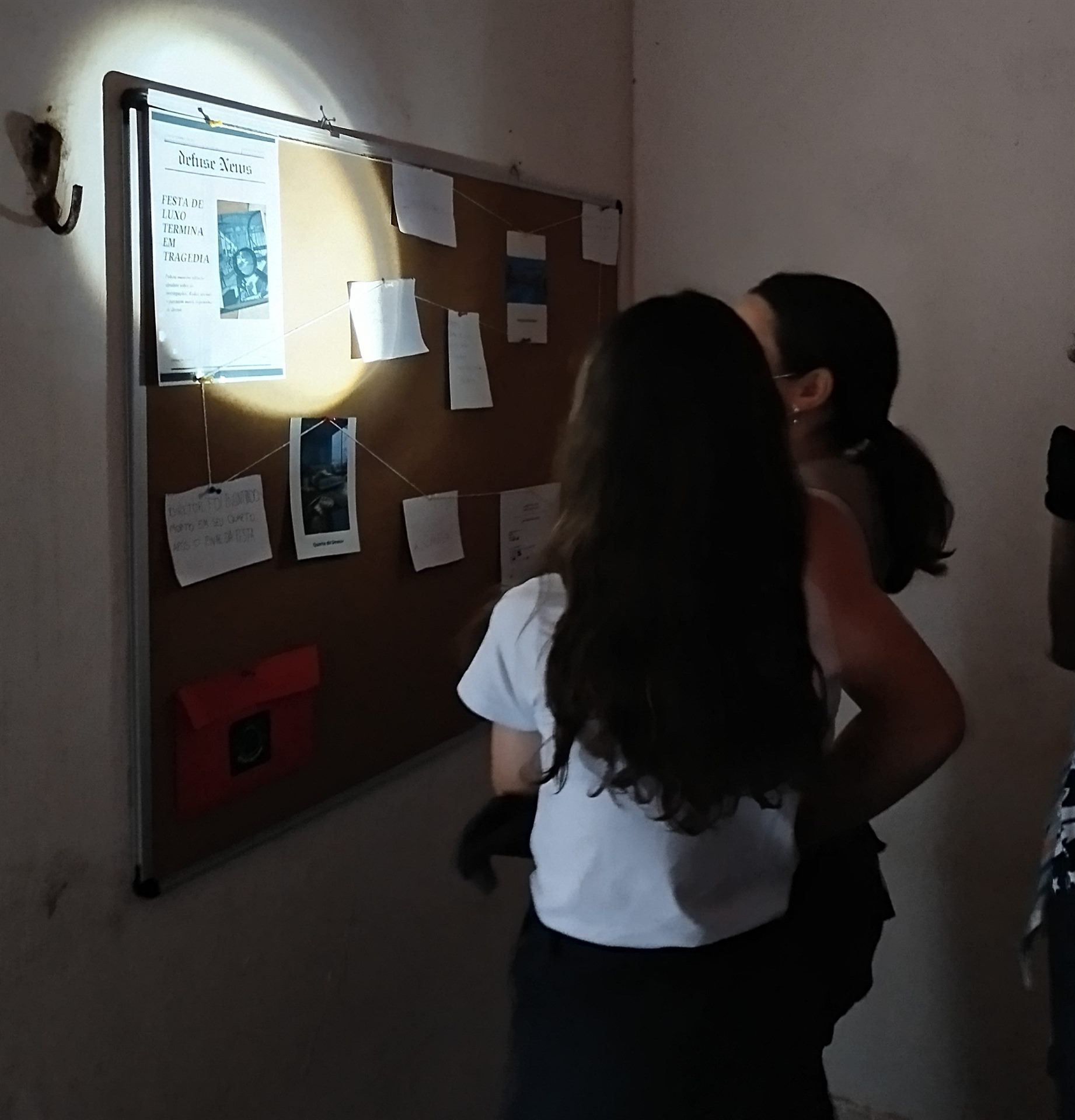 Participantes investigando o mural de pistas na experiência Defuse The Bomb