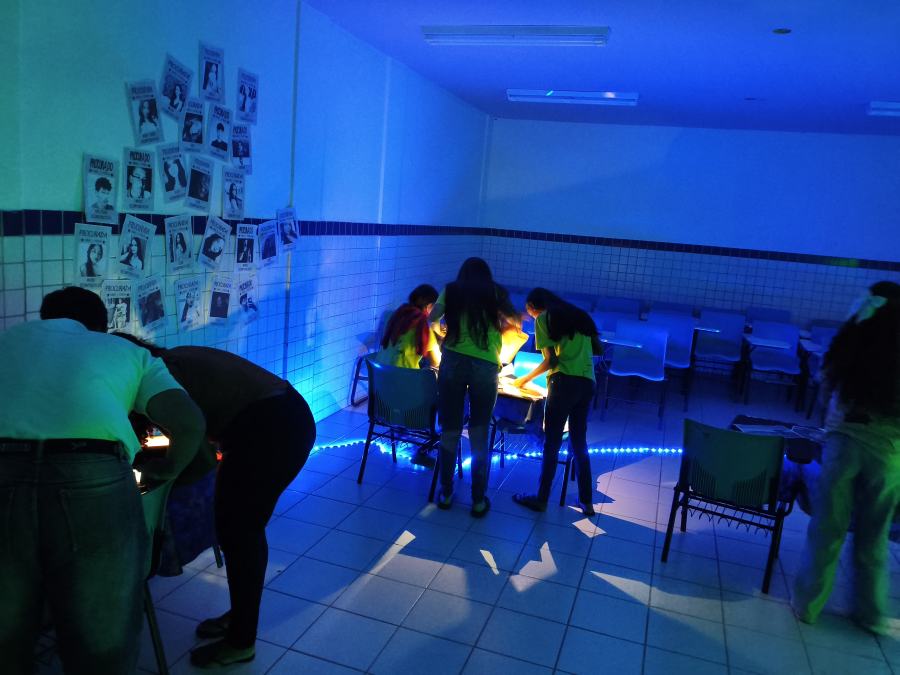 Equipe decifrando pistas em sala com luz negra